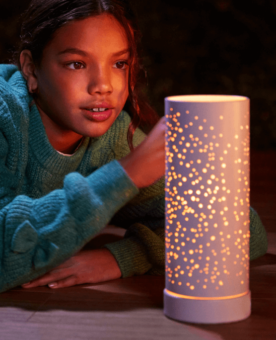 A young girl gazes wonderingly at the Aroma Light Diffuser.