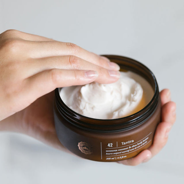 A person applying Tantra Sensuous coconut and shea body butter to their fingers