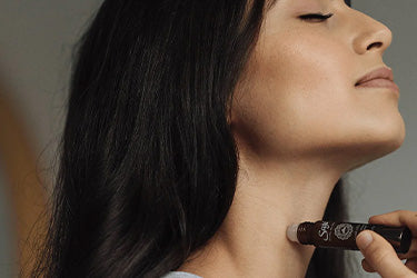 A women applying roll-on on her neck