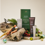 Winter Wonderskin kit, including Tingle Feet Balm, Renew Lip Mask, and Dermedial Carrot+ Lotion arranged among festive decor. 