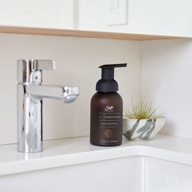 Hand soap bottle next to a metal faucet and white sink