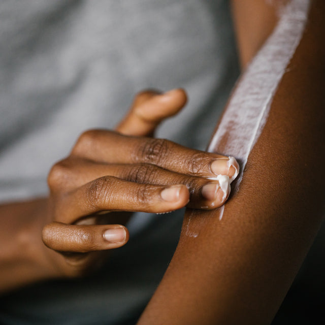 A person applying Carrot nourishing coconut & shea body butter into their arm